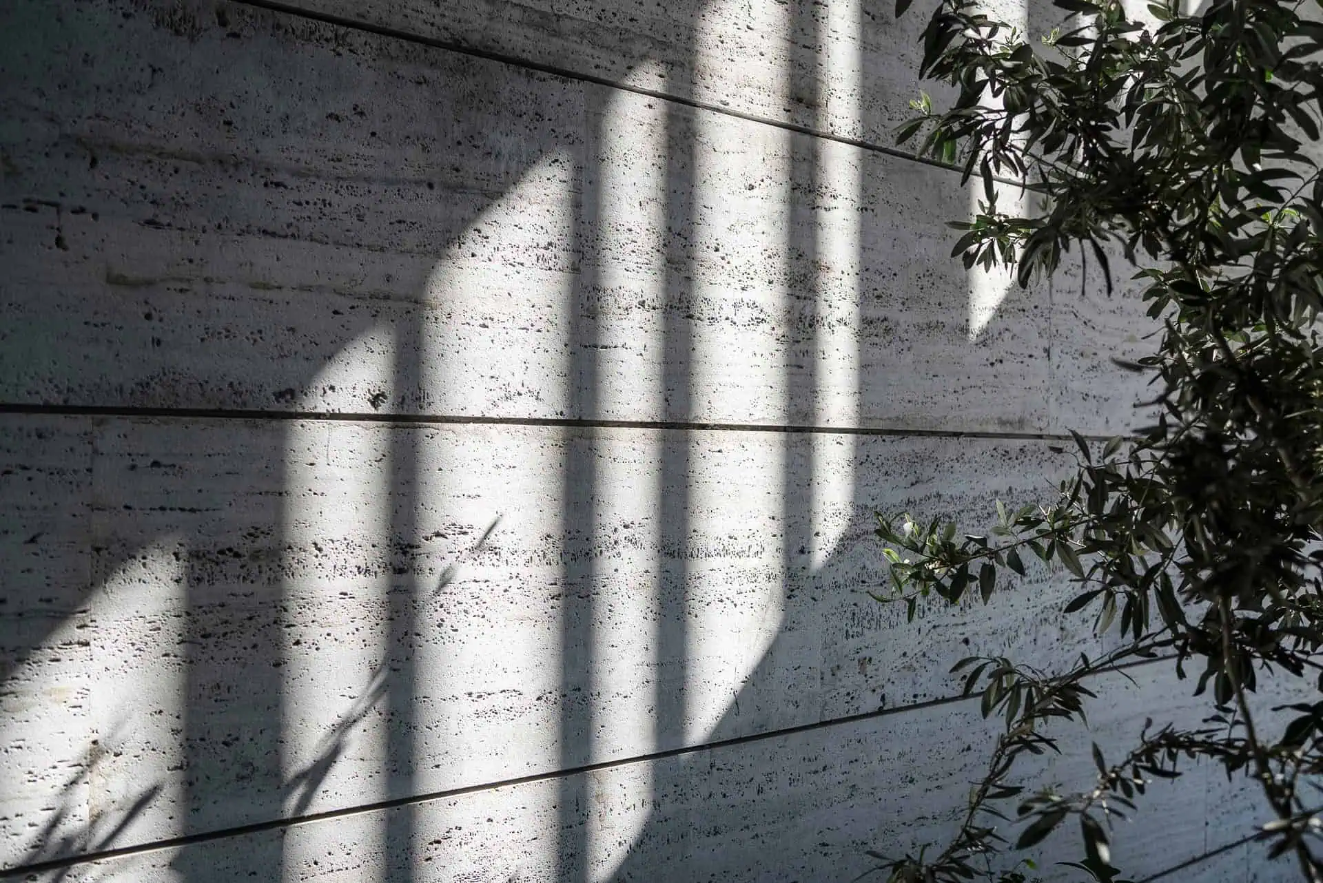 Light and shadow play on a travertine wall, Sanctuary project by ARK Architects