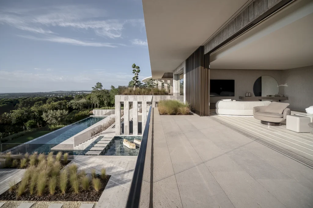 The upper terrace of Villa ENSO, with the living room opening out fully onto the Sotogrande landscape, an infinity pool and signature architecture by ARK Architects.